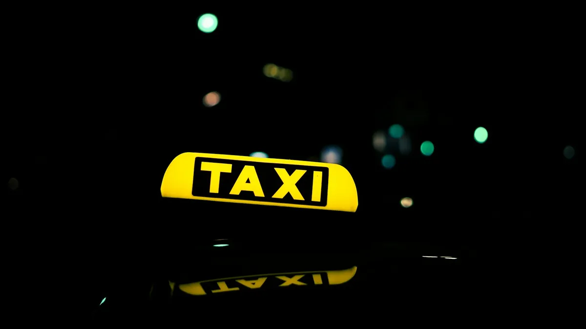 Taxi sign lit up at night