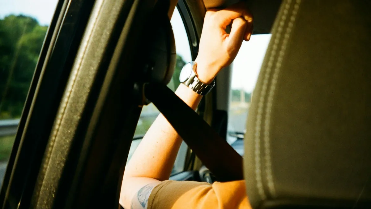 Passenger wearing a seatbelt across the shoulder in a car