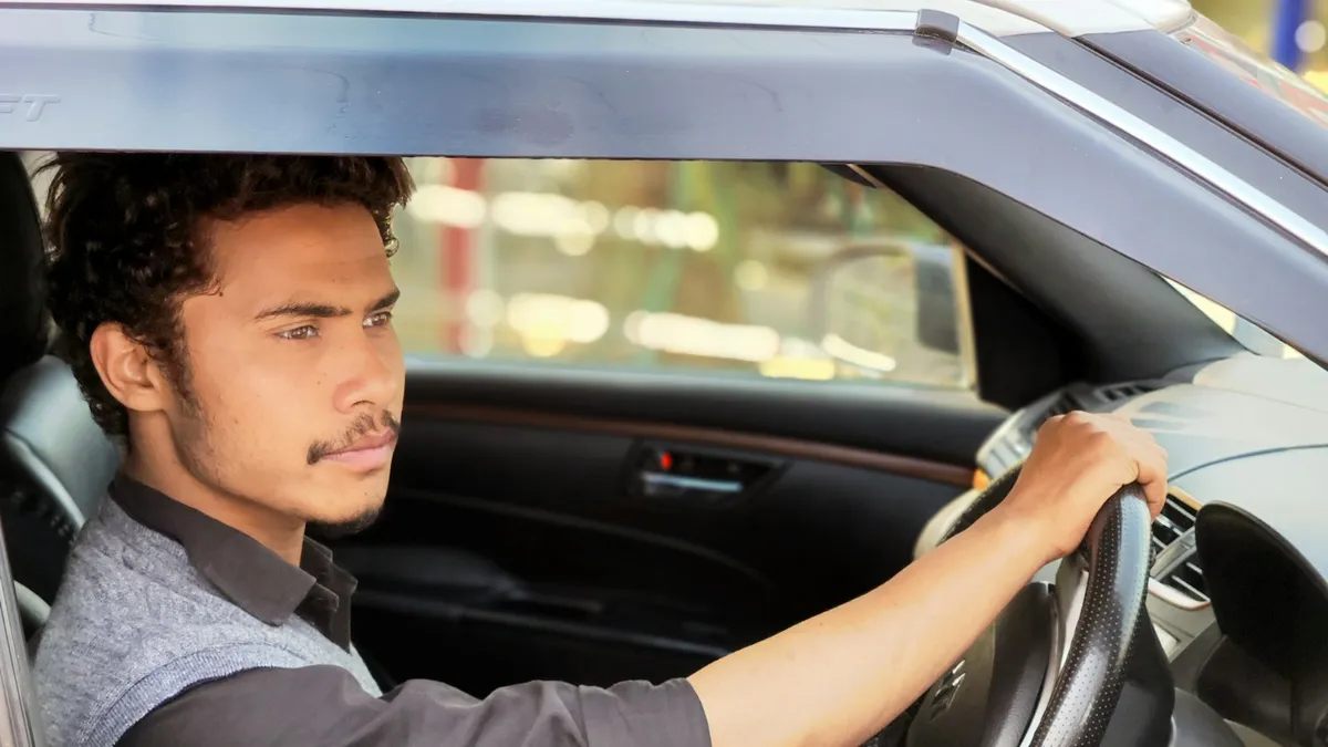 Young driver holding a steering wheel
