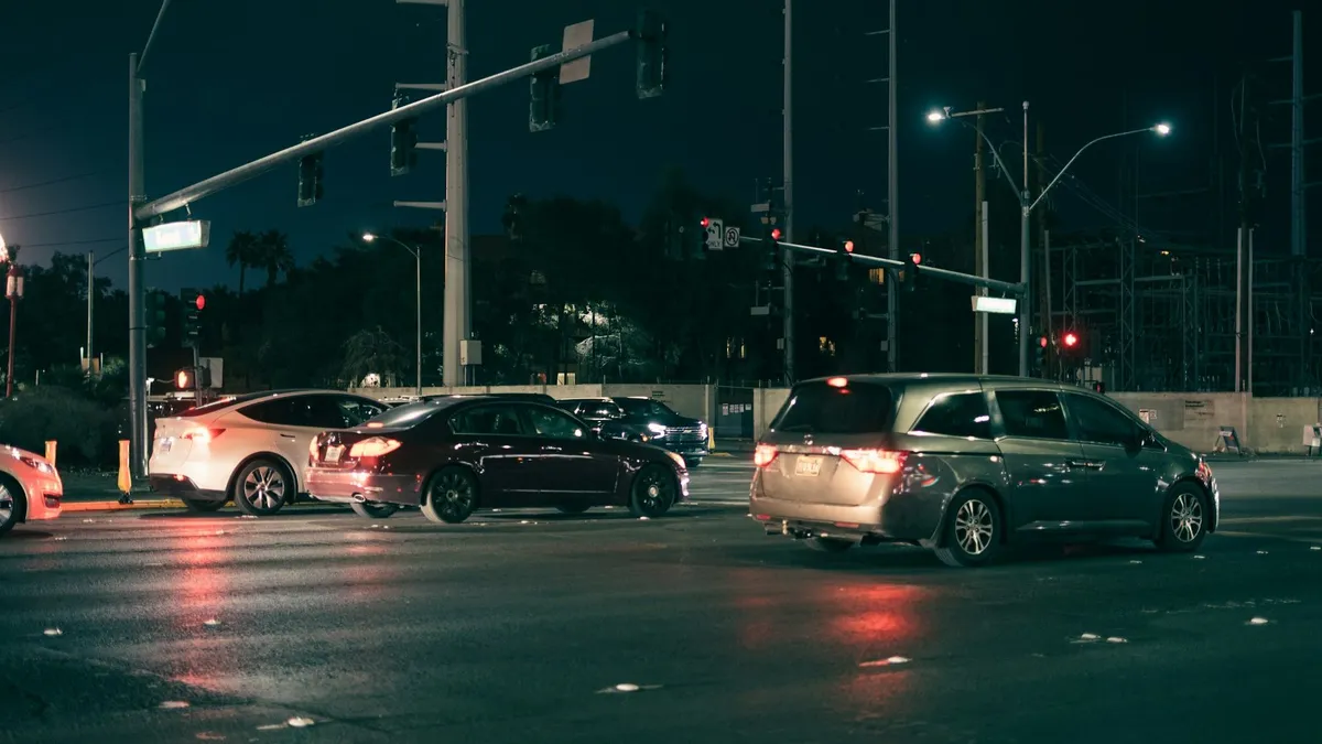 Cars waiting at a city intersection at night