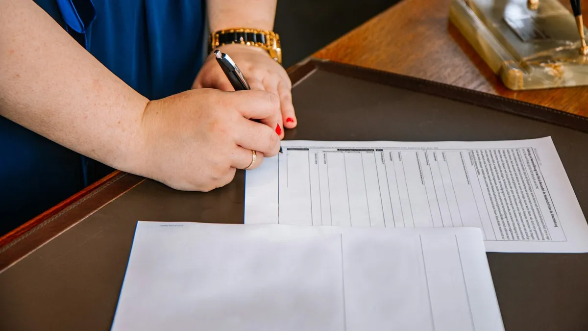 Person writing notes on legal documents at a desk