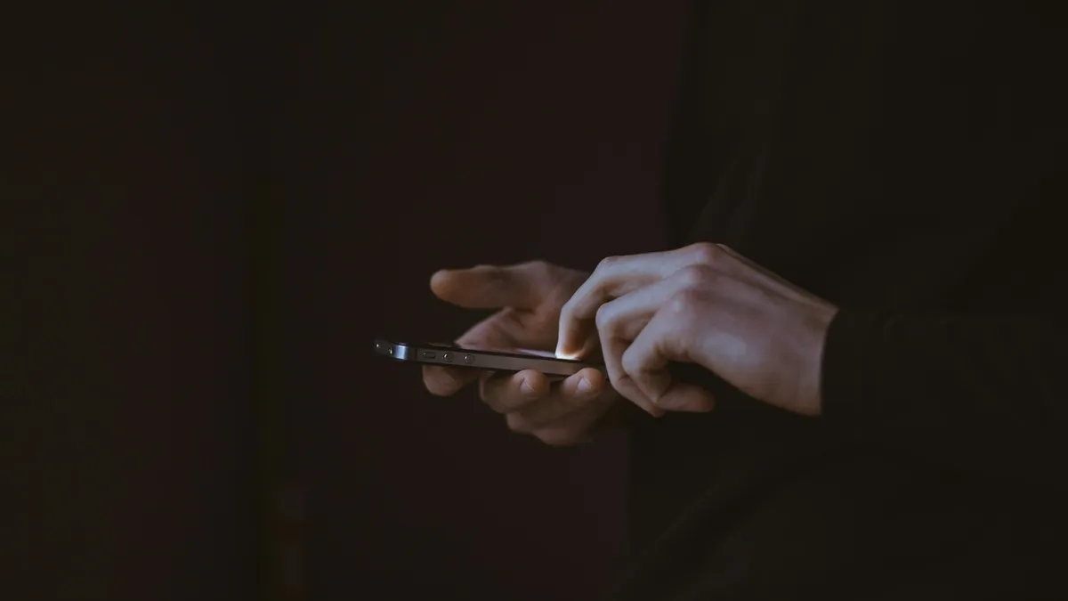 Person holding a smartphone in a dark room