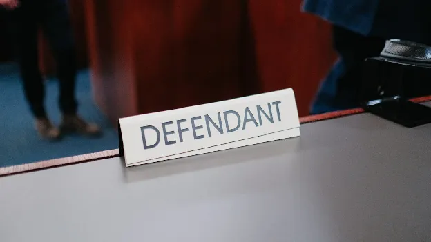Defendant sign on a court bar table