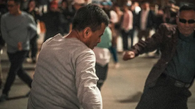 Two men in a physical confrontation on a city street at night